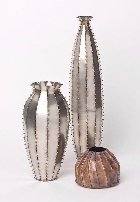 Sculptural metal vases with a beaded ribbed texture in silver and bronze