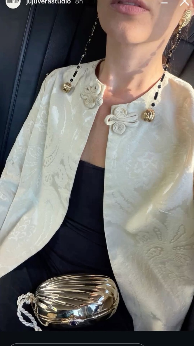 Jewelry maker examining a stone through a loupe at her workbench