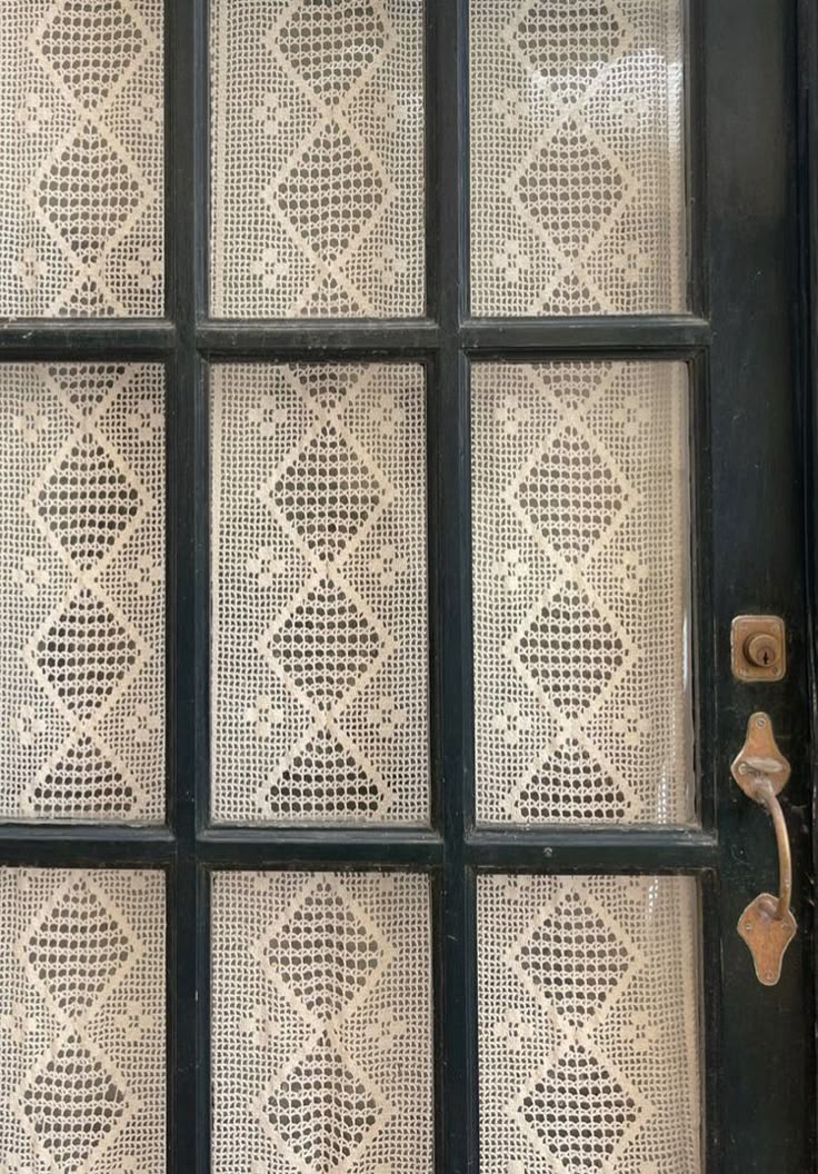 Vintage door with crocheted lace panels set in dark green wood