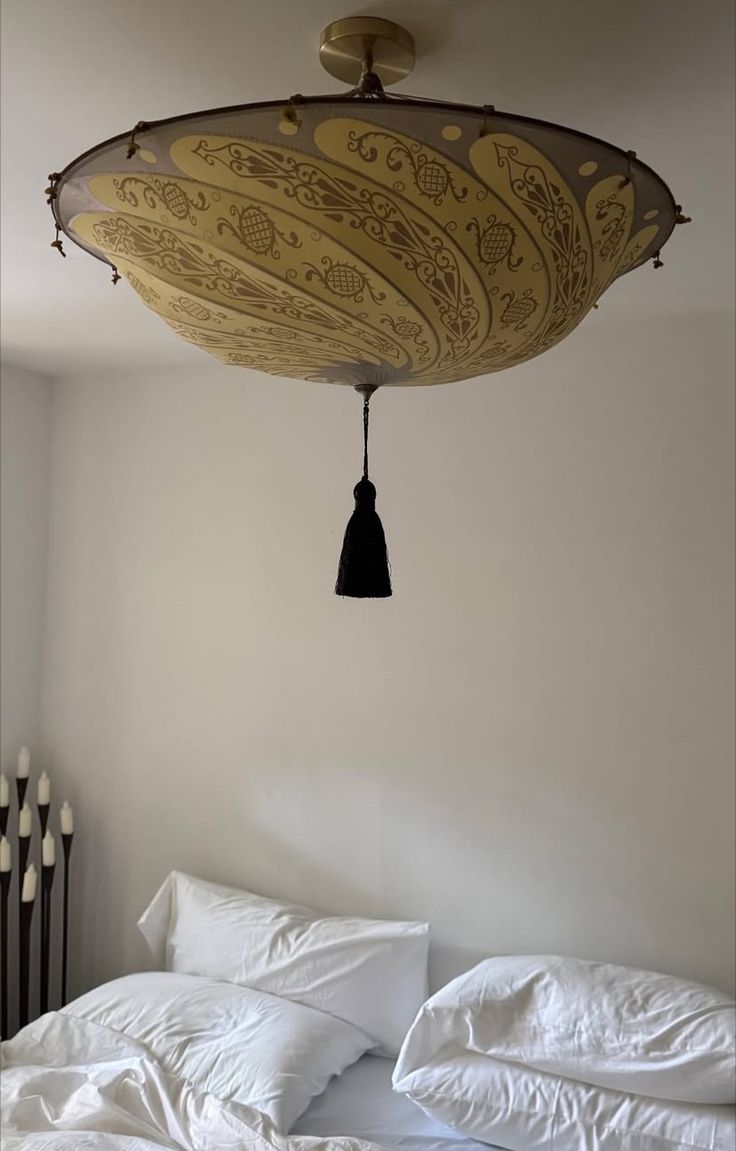 Domed fabric ceiling pendant with a patterned shade and black tassel pull