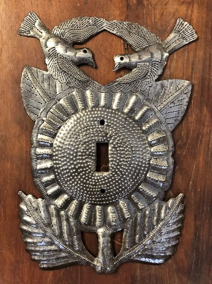 Ornate silver switch plate with a pair of birds and leaves