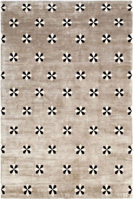 Beige rug with a repeating black and cream star-flower pattern