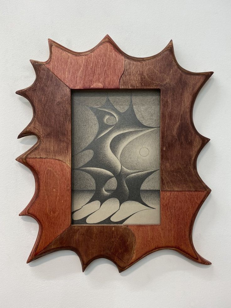 Sunburst-shaped wood picture frame in warm rust tones